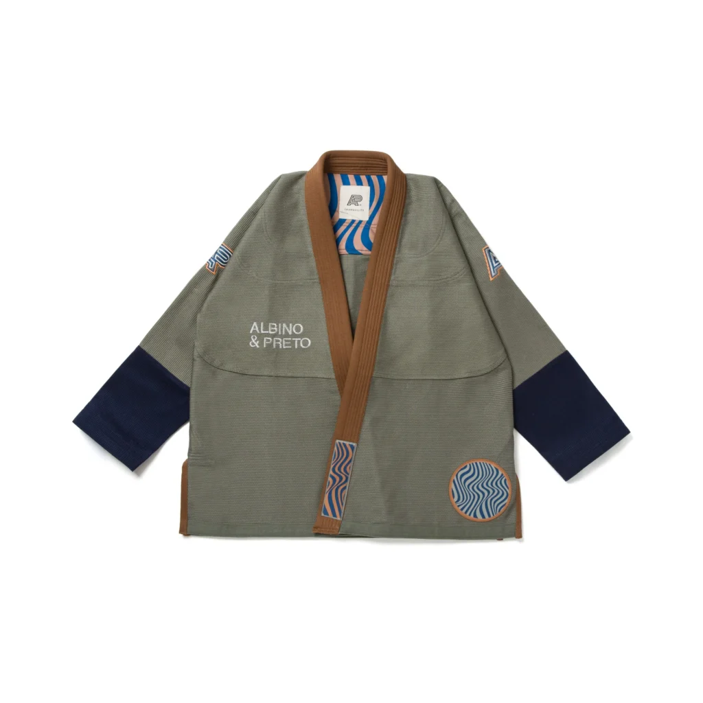Albino & Preto Tranquility Gi in earth-tone colors, featuring a 450gsm pearl weave jacket and "Novo" cut twill pants, adorned with breath-flow patch artwork, designed for Brazilian Jiu-Jitsu practitioners.
