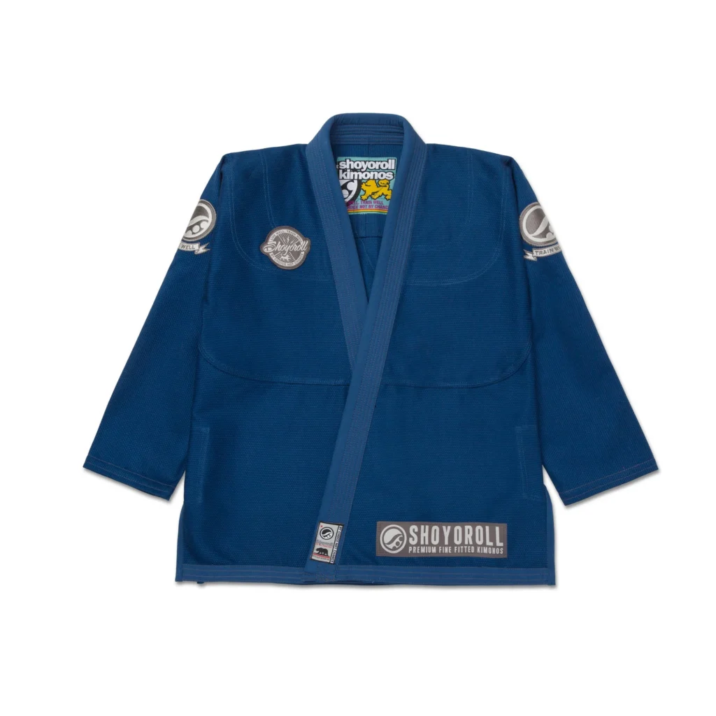 Shoyoroll Atlas Competitor Gi in SYR Blue, featuring a lightweight 425g pearl weave jacket and 10oz double diamond ripstop pants, displayed on a white background with subtle gray patchwork accents.